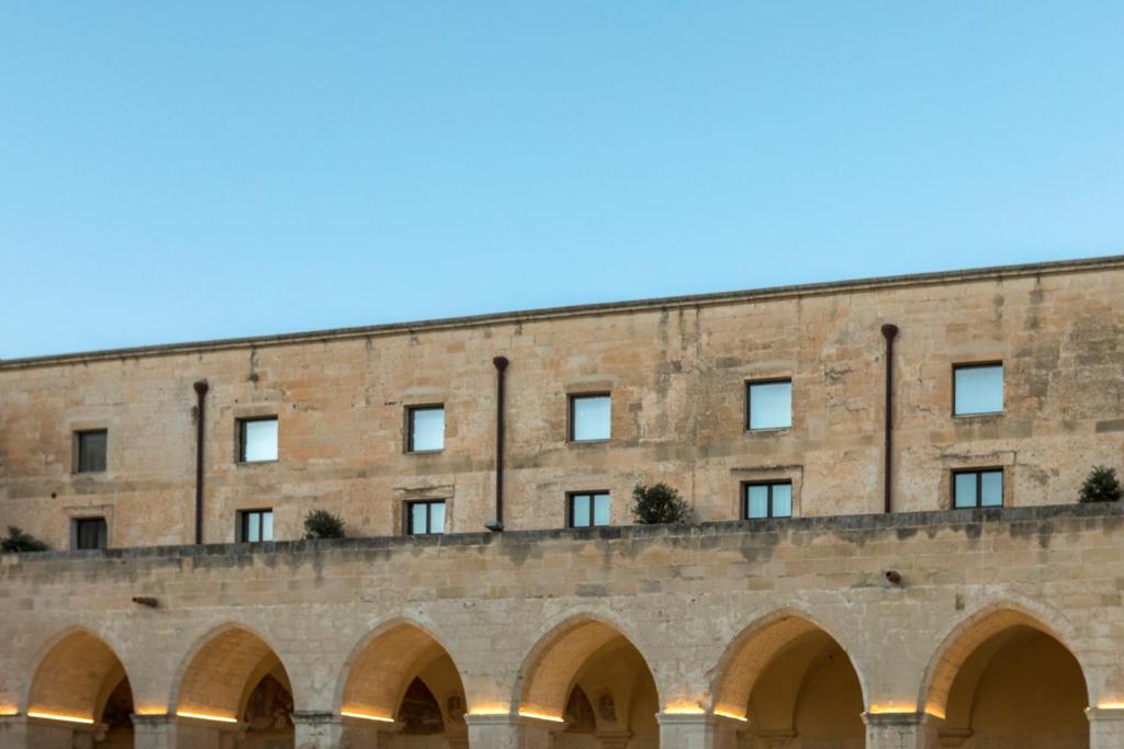 莱切Chiostro dei Domenicani - Dimora Storica的前面有拱门的大砖砌建筑