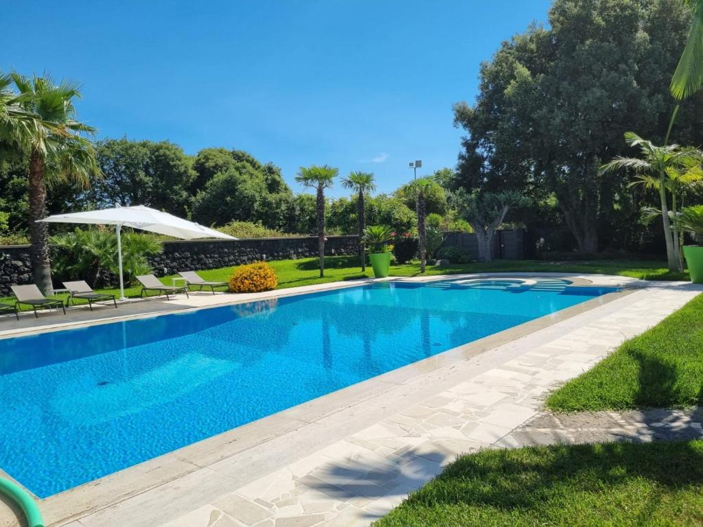 阿奇雷亚莱Villa Arianna的庭院里的一个蓝色海水游泳池