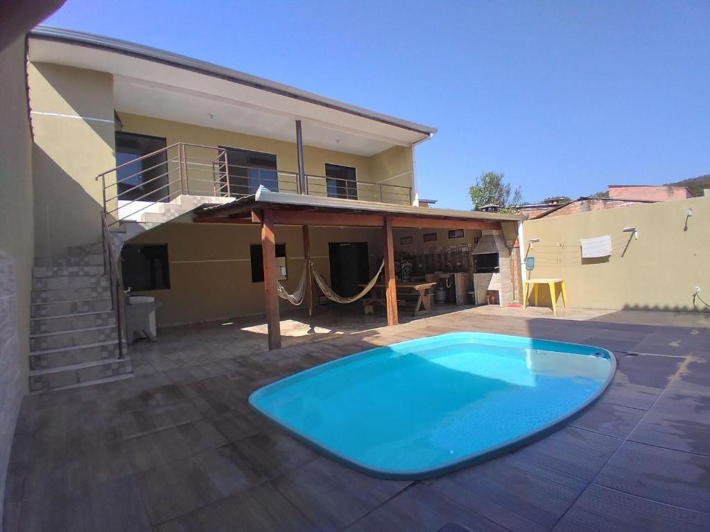 马蒂尼奥斯Sobrado com piscina em Caioba的一座大蓝色游泳池,位于房子前