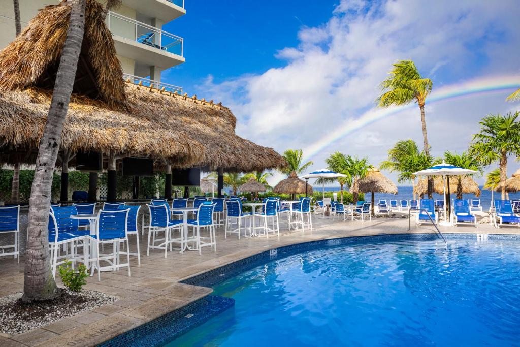 基拉戈Reefhouse Resort and Marina的一个带椅子和遮阳伞及彩虹的游泳池