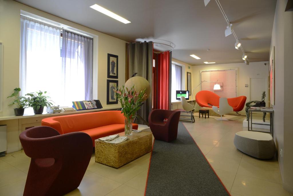 的里雅斯特哥伦比亚酒店的客厅配有橙色沙发和椅子