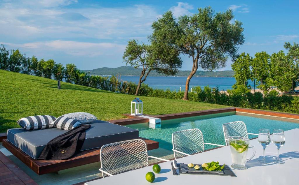 欧拉努波利斯Avaton Luxury Beach Resort - Relais & Chateaux的别墅 - 带游泳池和桌椅
