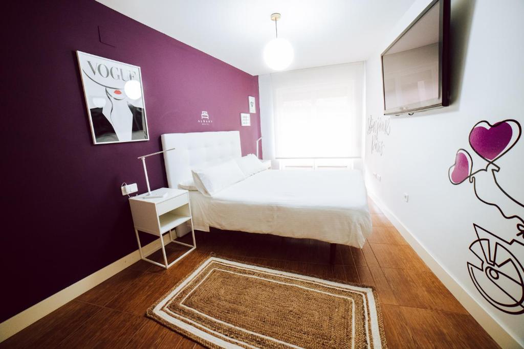 莱昂波佐旅馆的卧室配有白色的床和紫色墙壁