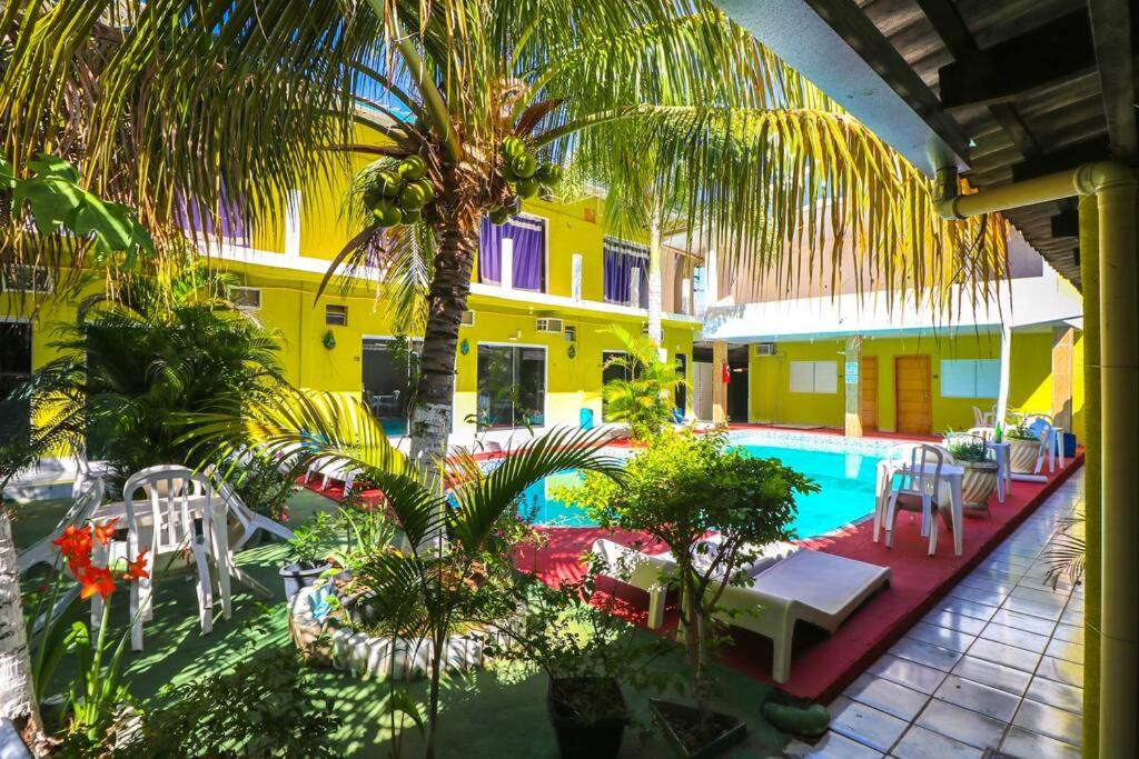 阿鲁阿南水瓶座旅馆的一个带游泳池、棕榈树和椅子的度假酒店