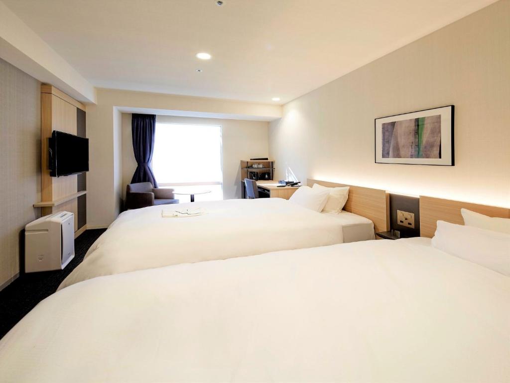 东京Tmark City Hotel Tokyo Omori - Vacation STAY 26391v的酒店客房设有两张床和窗户。