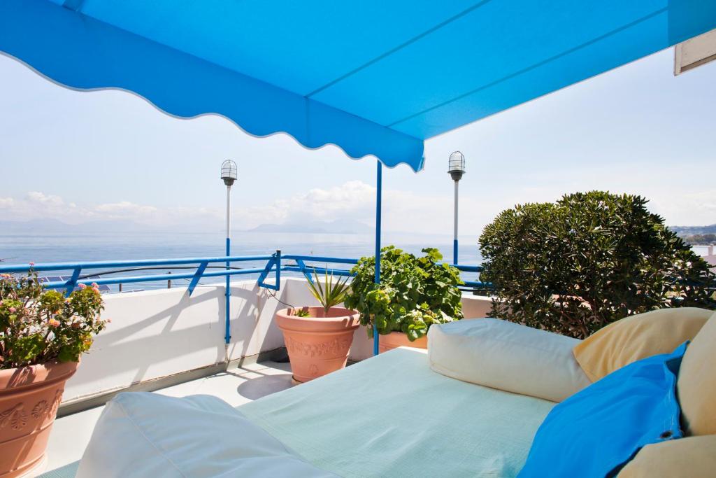 西洛卡特伦黛芙妮俱乐部公寓式酒店的阳台配有蓝色雨伞和一些植物