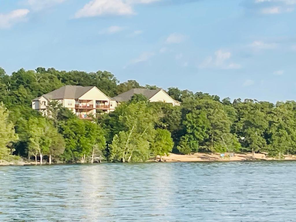 布兰森Lakefront Indian Point Condo with Boat Slip的水体岸边的房子