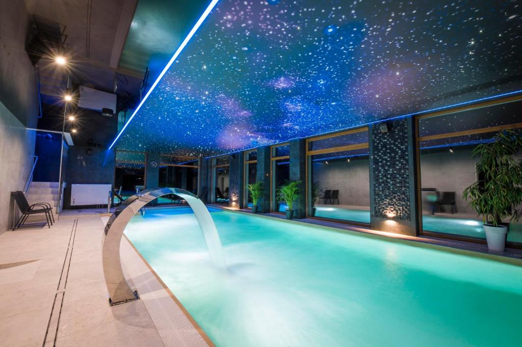 韦巴Sailor Łeba的一座拥有星空天花板的建筑中的游泳池
