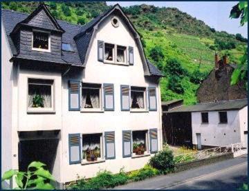科赫姆Gästehaus Aladin的一座大白色房子,山上设有窗户
