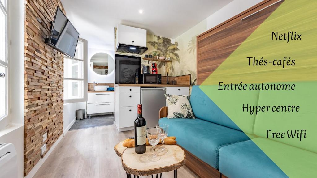 蒙托邦Chez Ingres - Le Nid - Joyau caché en centre ville的一间带蓝色沙发的客厅和一间厨房