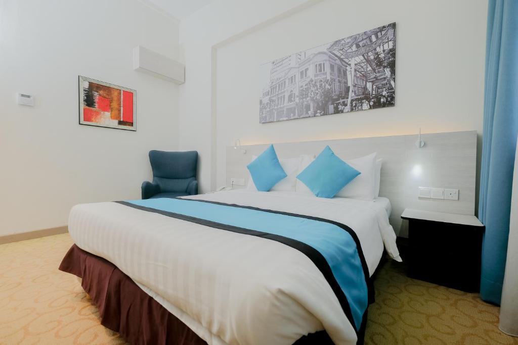 吉隆坡EDC Hotel Kuala Lumpur的酒店客房配有一张带蓝色枕头的大床