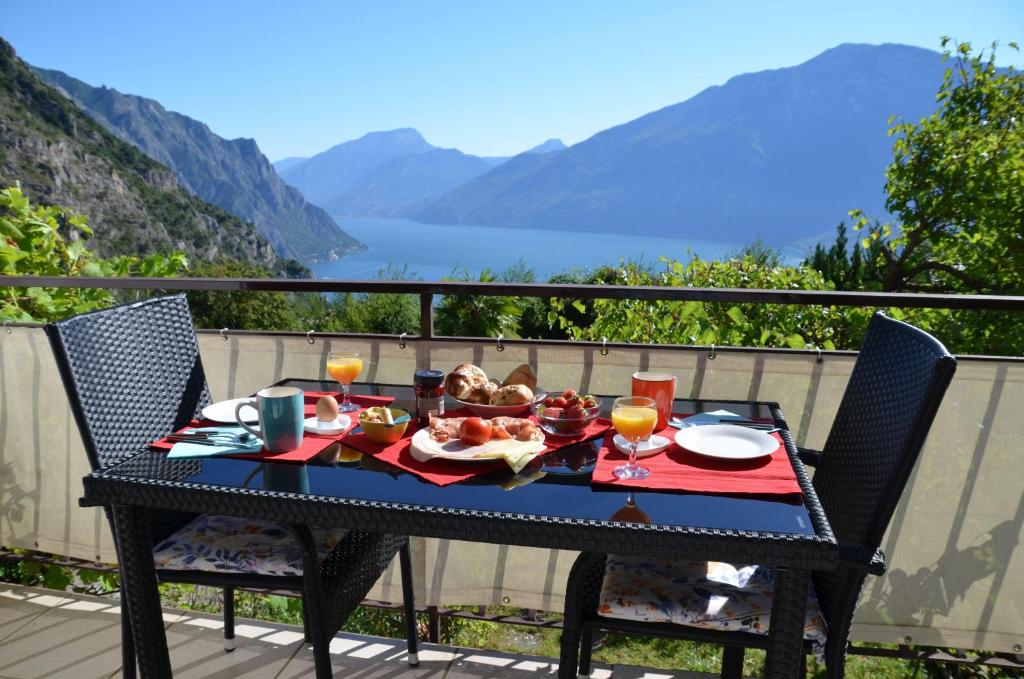 特雷莫西内Ferienwohnung-Casa-Uta-Gardasee-Limone-Tremosine的阳台上的黑色桌子上摆放着食物
