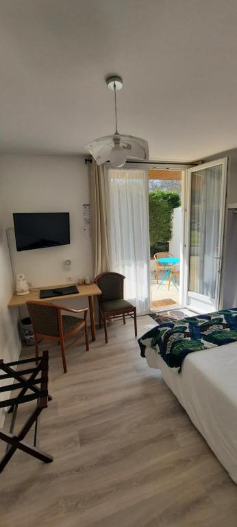 Argoules奥伯格杜格罗斯提勒尔酒店的一间卧室配有一张床、一张书桌和一台电视