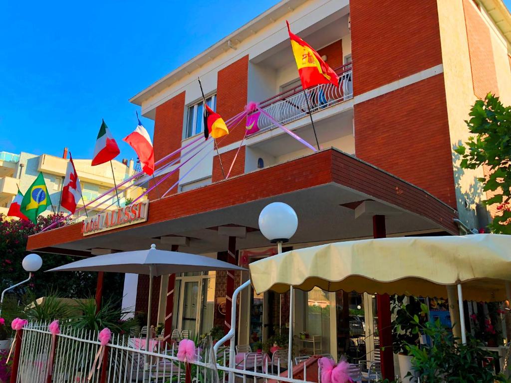 里米尼Hotel Alessi** Rimini的大楼一侧有旗帜的酒店
