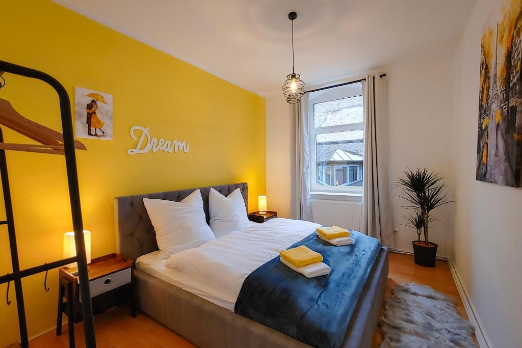 布伦瑞克M-OASE Wohlfühlen an der Oker I Küche I Netflix的一间卧室设有一张黄色墙壁的大床
