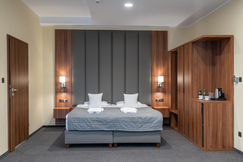 比得哥什沃德尼克酒店的一间卧室配有一张床,上面有两条毛巾