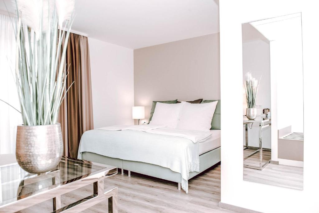 巴德索登陶努斯Concorde Business Boutique Hotel的白色卧室配有床和镜子