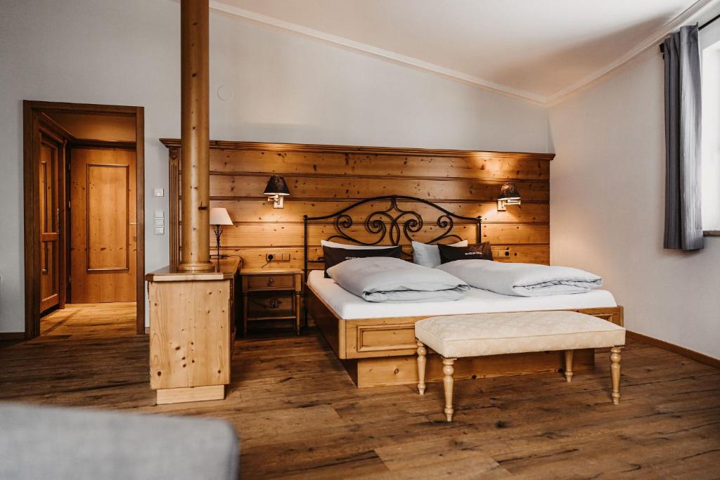 希洛谢克Verwöhn-Wellnesshotel Walserhof的一间卧室设有一张带木墙的大床