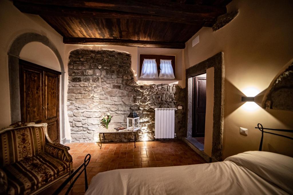 维泰博Il giardino nel borgo的一间卧室设有一张床和石墙