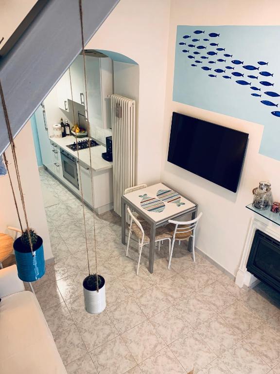 韦内雷港Appartamento SoloSoleMare的一间带桌子和电视的小客厅