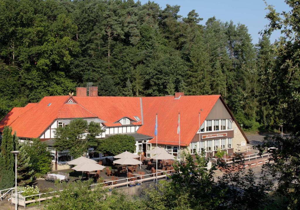 希察克尔Ferien- und Wellnesshotel Waldfrieden的一座带橙色屋顶的建筑,配有桌子和遮阳伞