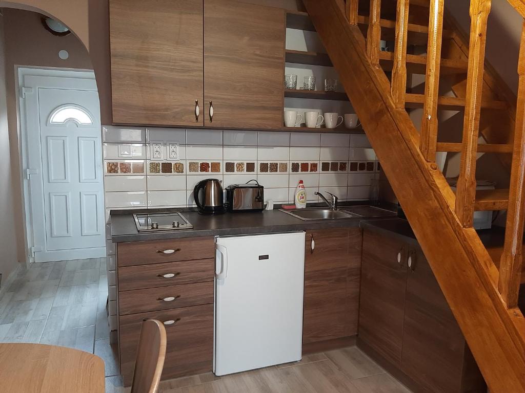 博加奇Egniss Apartman的厨房配有白色冰箱和木制橱柜。