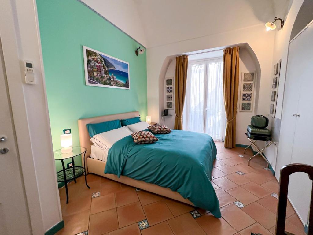 阿马尔菲Amalfi Andrea's House的一间卧室配有一张床、一张桌子和一个窗户。