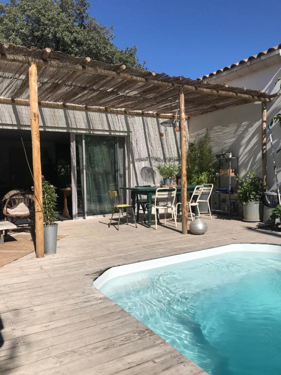 滨海萨纳里Maison d hôtes LA VILLA MADELEINE的后院设有游泳池和木甲板