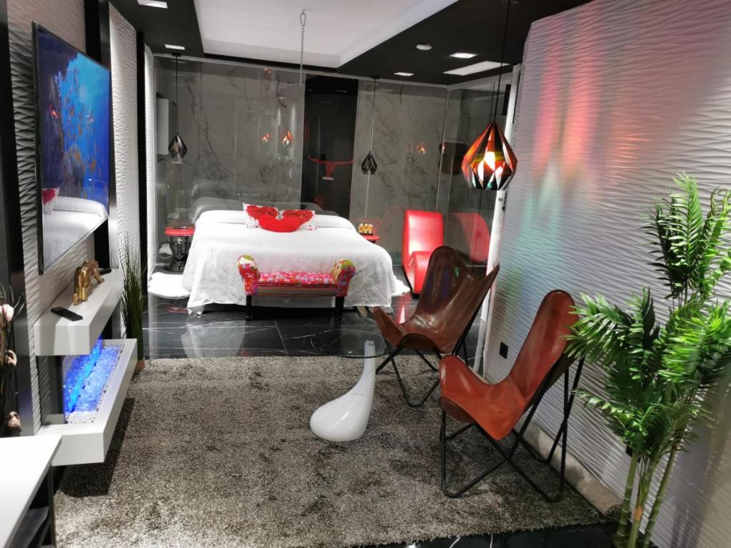 BabilafuenteLexury Suite Acqua的配有一张带椅子和一张桌子的床的房间