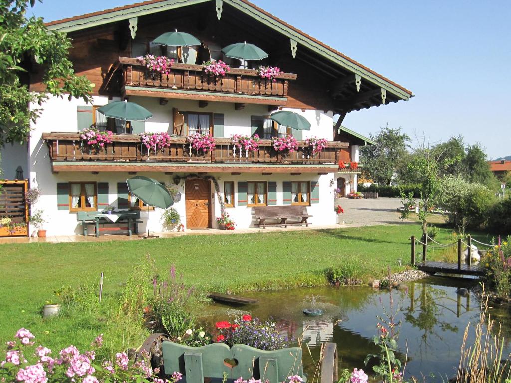 因泽尔Hausernhof的一座带池塘和鲜花阳台的建筑