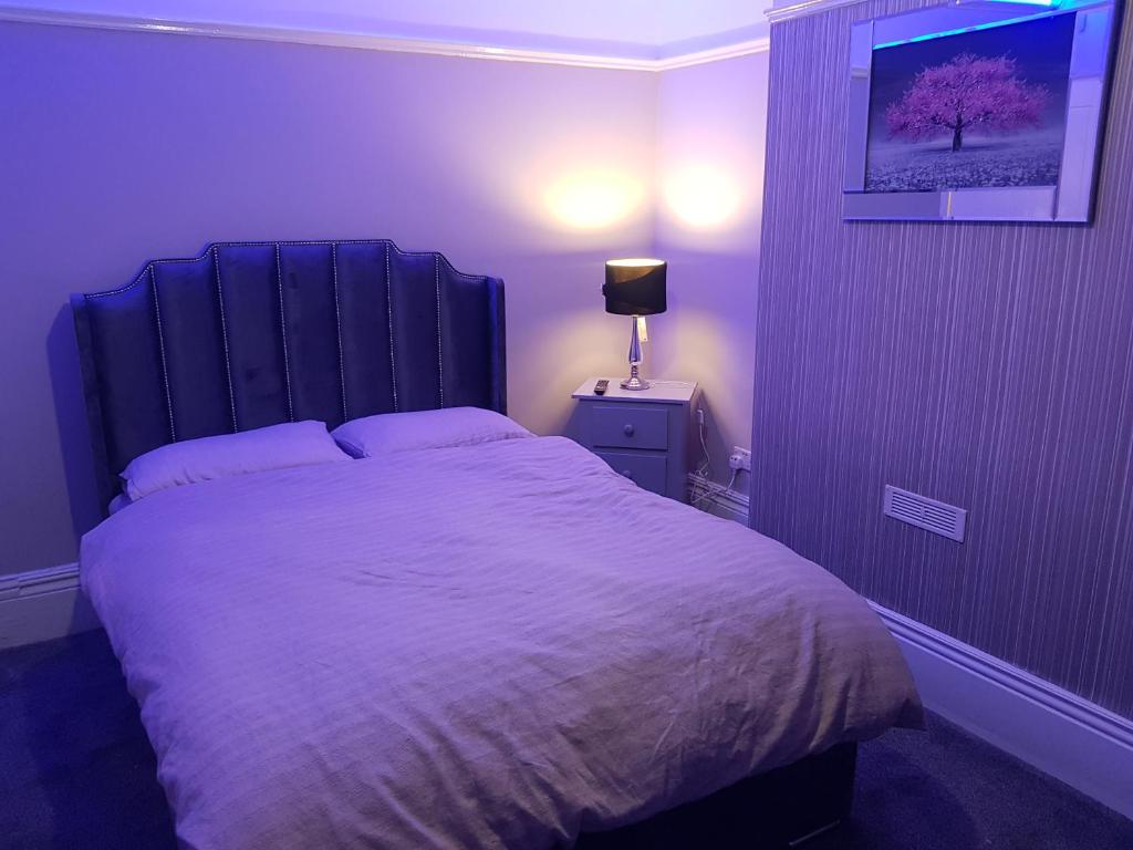 谢菲尔德Highfields Living的紫色客房内的一间卧室配有一张大床