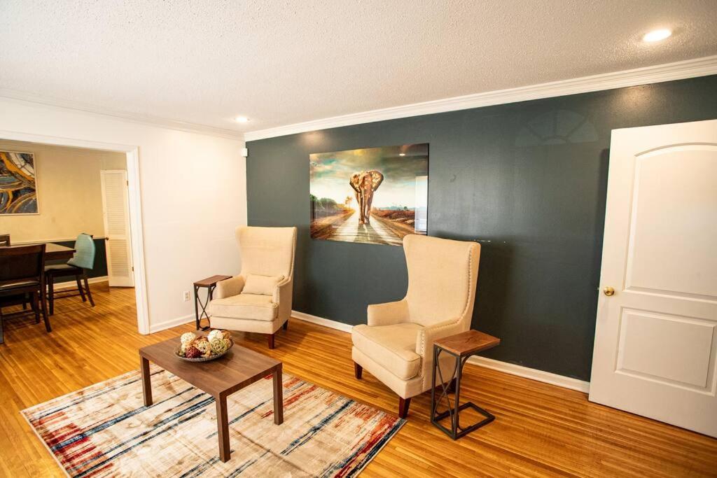 孟菲斯The Retreat at Graceland的客厅配有两把椅子和墙上的绘画