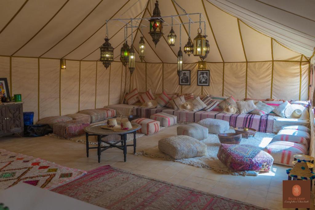 梅尔祖卡Beldi camp的帐篷内配有沙发和枕头的房间