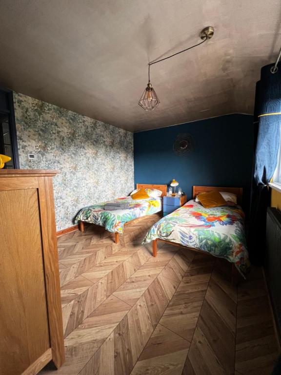牛顿艾克利夫Jackson place的配有蓝色墙壁和木地板的客房中的两张床