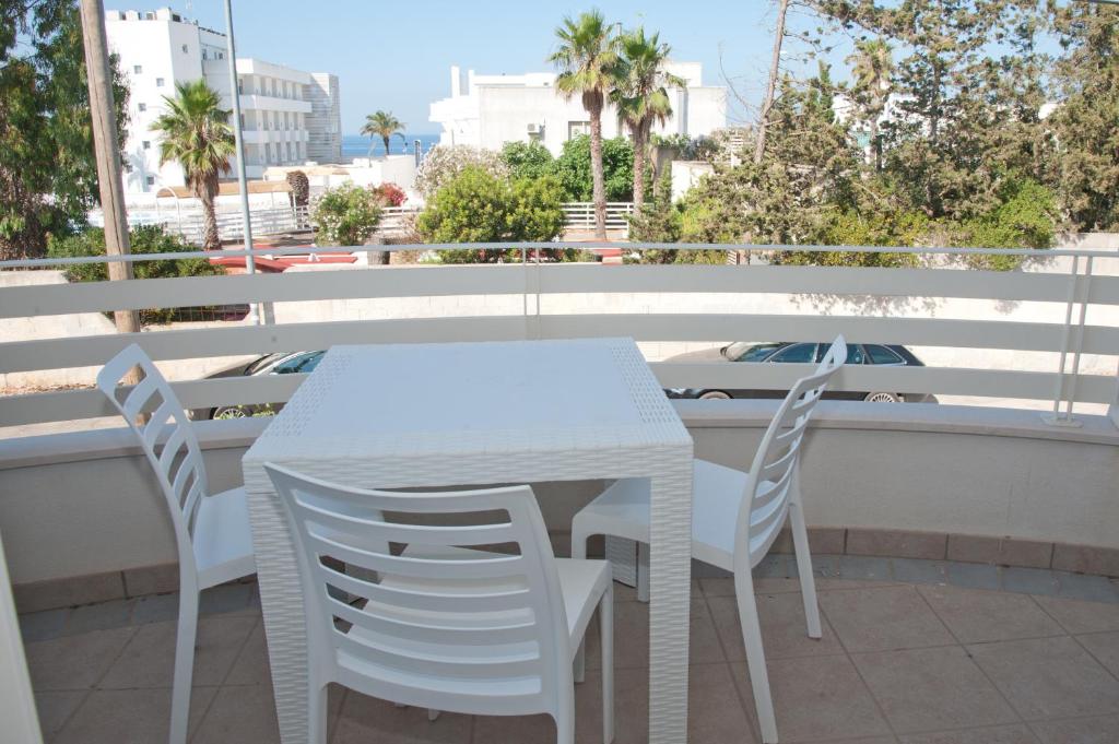 托雷圣乔万尼乌SoleSalento 32的阳台上配有白色的桌椅