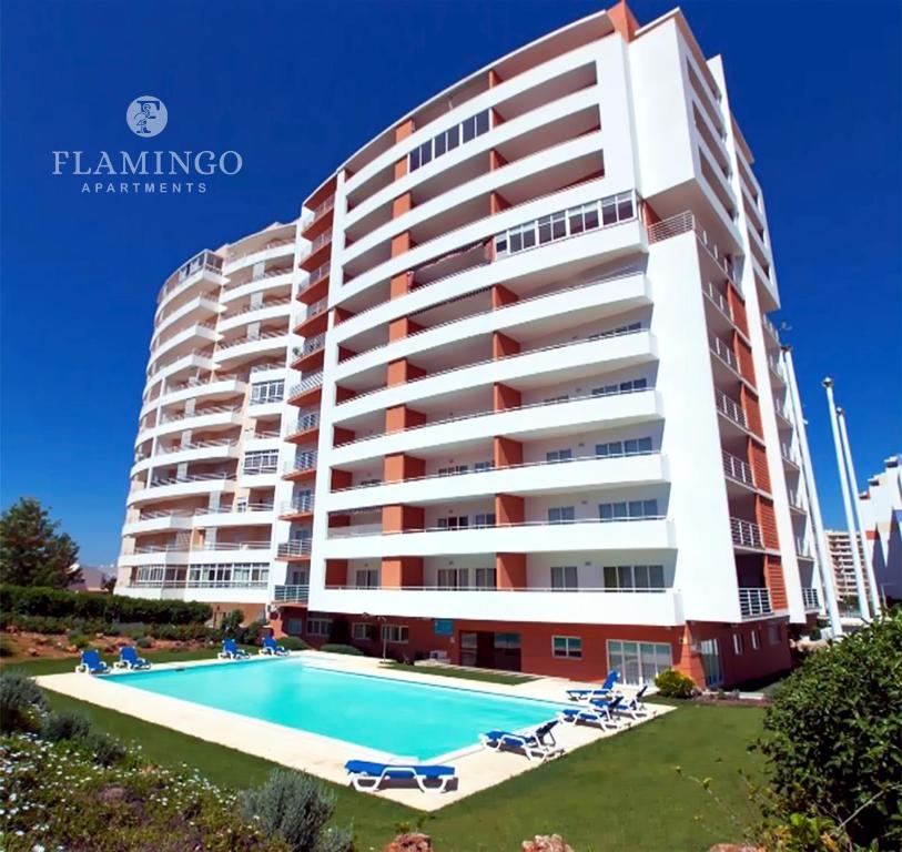 波尔蒂芒Flamingo Apartments的一座大型建筑,前面设有一个游泳池