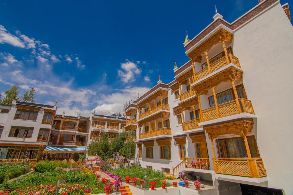 列城Hotel Jigmet, Leh的庭院里一群花卉的建筑