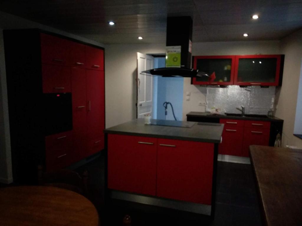 维泰勒Vittel location meublé的红色的厨房,配有水槽和红色橱柜