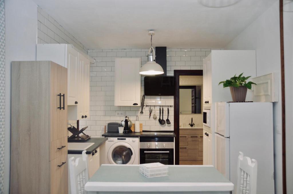 桑提亚纳德玛Apartamento Hiedra的厨房配有白色橱柜和白色冰箱。