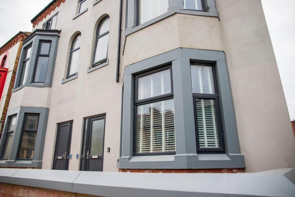 布莱克浦Withnell Stays - Apartment One - Ground Floor的黑窗和白色百叶窗的房子