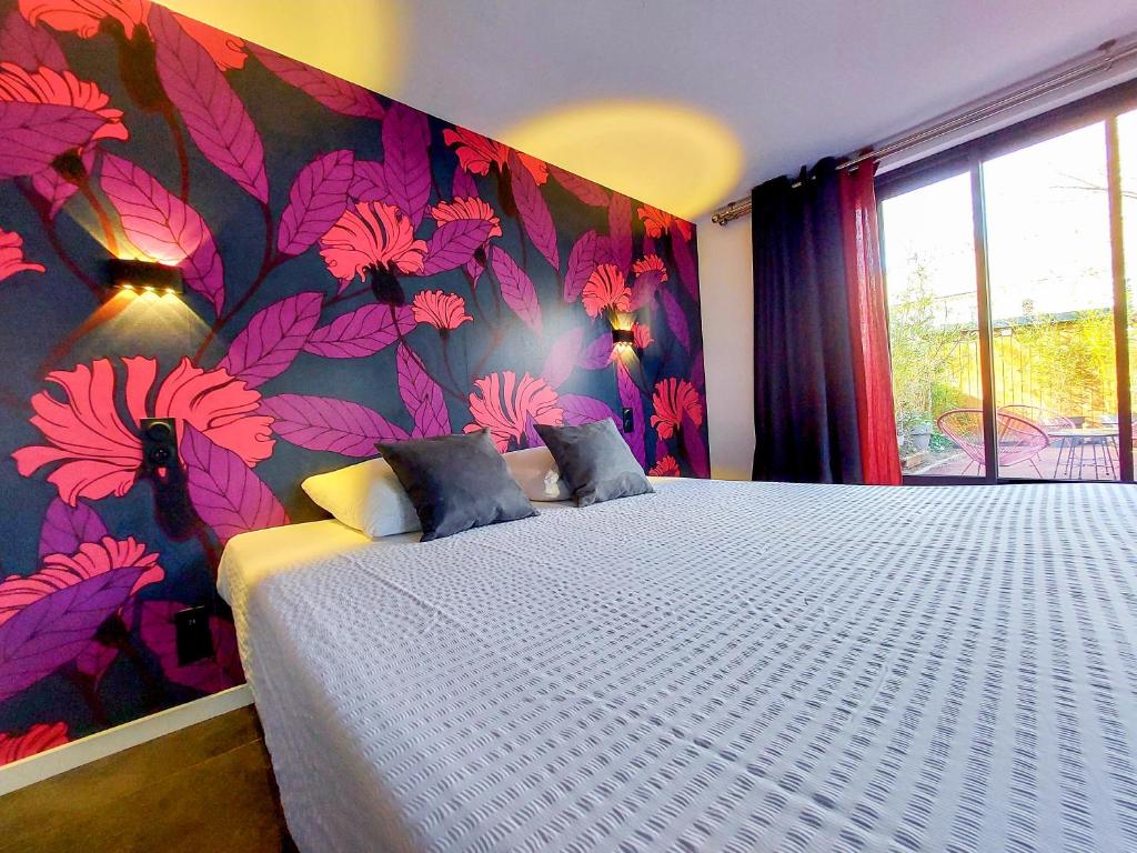 阿姆博斯Le Huis Clos的一间卧室配有一张带花卉壁纸的大床