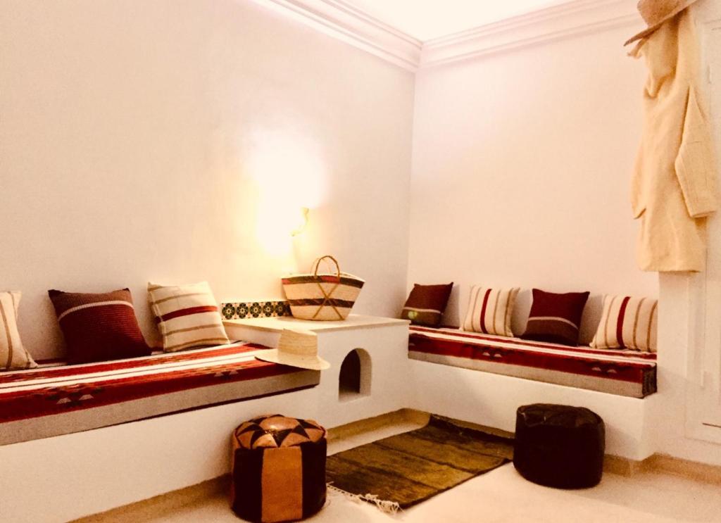Al ḨaddādahDar ABDELKRIM的一间客厅,客厅内配有两张长椅