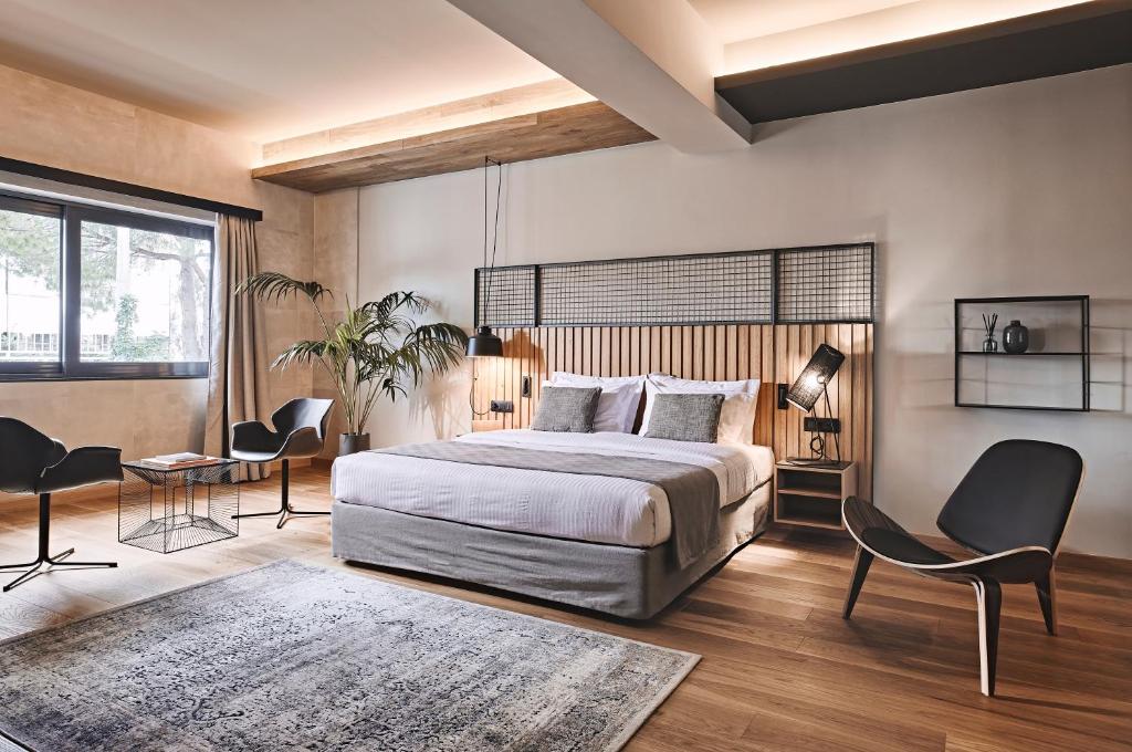 雅典Cama Luxury Suites的卧室配有一张床和一张桌子及椅子