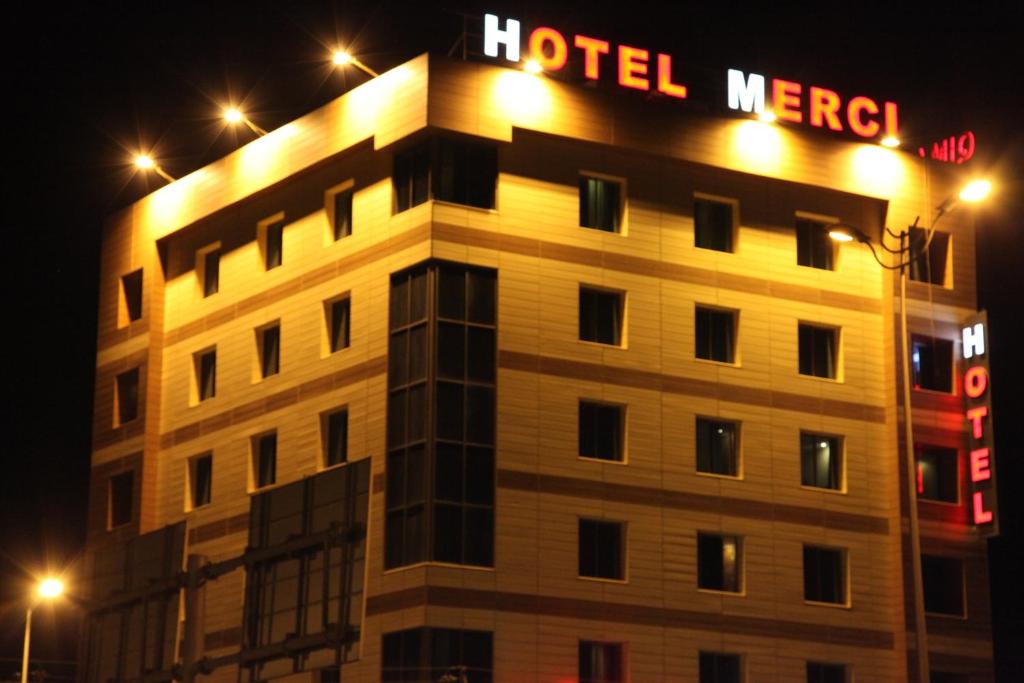 埃尔比勒埃尔比勒美尔奇酒店的一座在晚上有酒店慈善标志的建筑