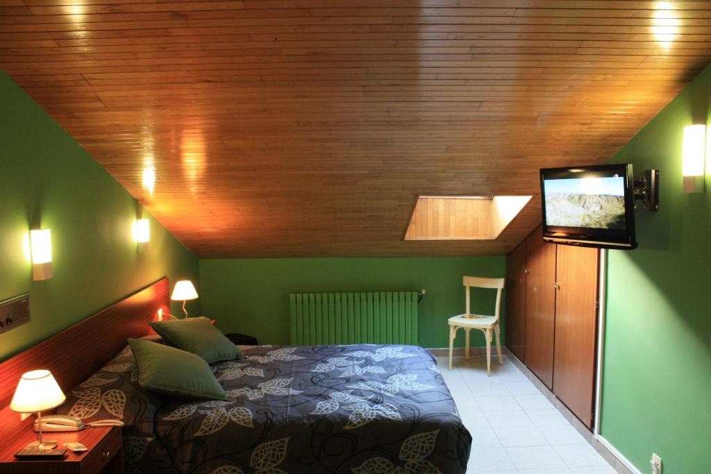 安道尔城七把钥匙酒店的一间卧室配有一张床和一台平面电视