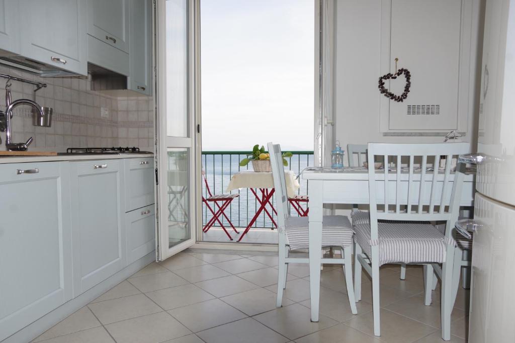 维耶特里Casa Colombo的一间带白色桌椅的厨房和一个阳台