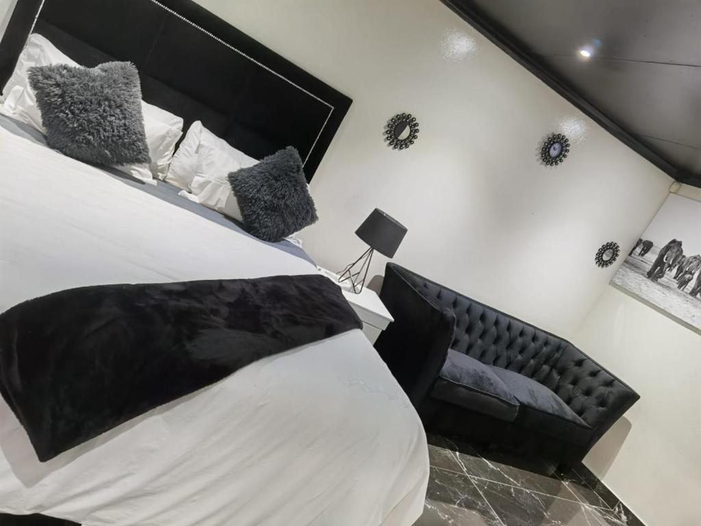 约翰内斯堡Semeni Asante Guesthouse的一间卧室配有一张大床和黑色床头板