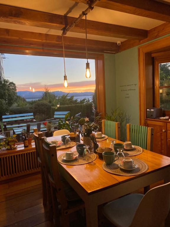 圣卡洛斯-德巴里洛切Selva India Suites的餐桌、椅子和大窗户