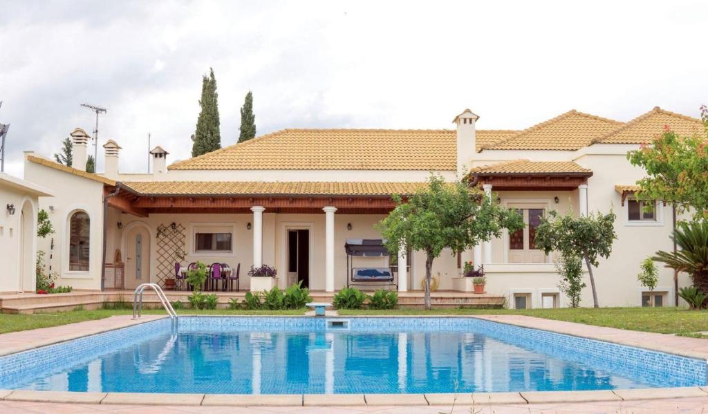 Ágios GeórgiosLaki Villa with pool and jacuzzi的别墅前设有游泳池