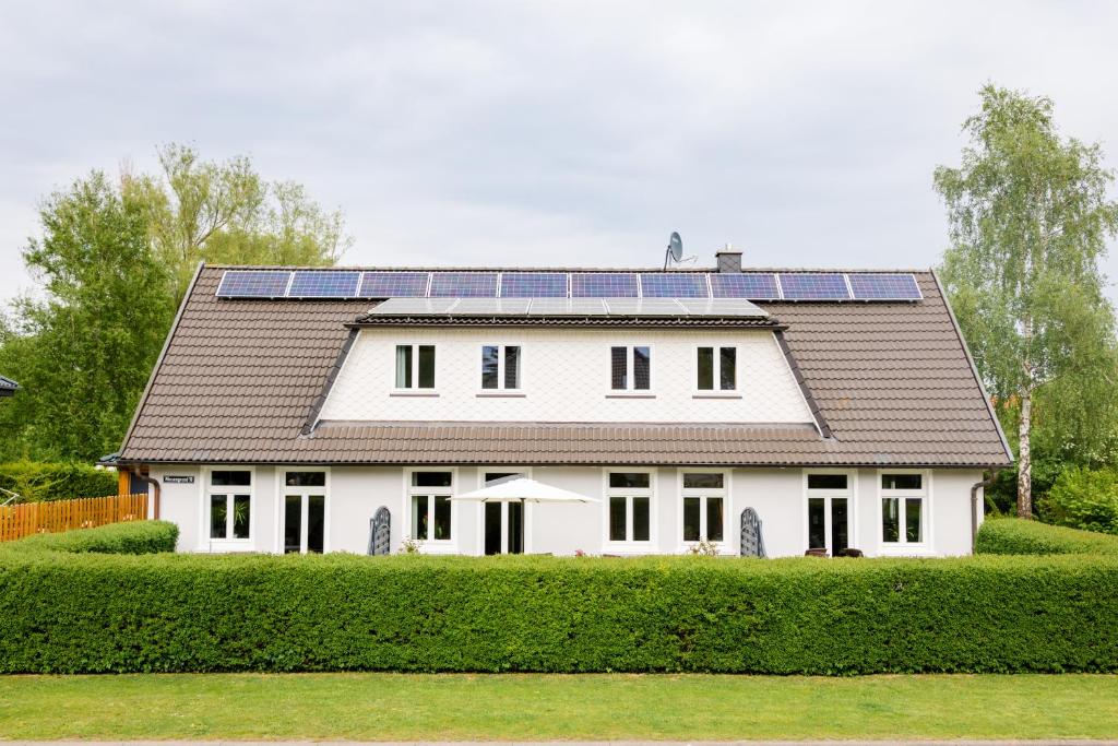 奥斯赛拜-屈隆斯博恩Drum &Dran的屋顶上设有太阳能电池板的白色房子